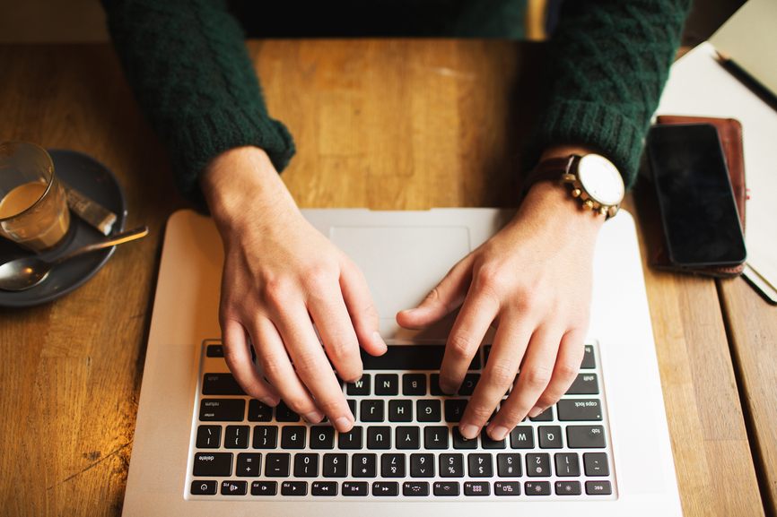 Hands typing on a laptop keyboard