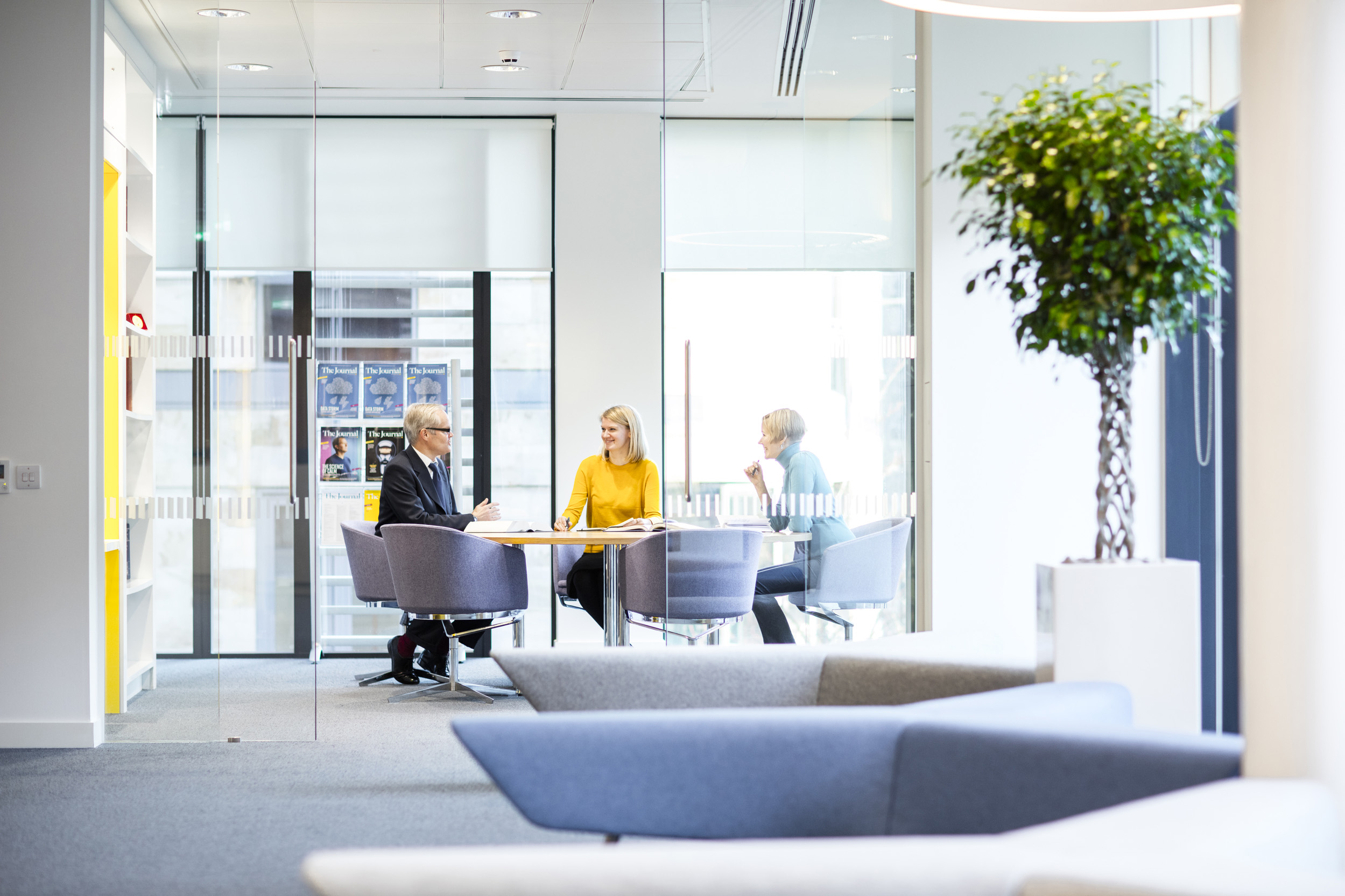 View of three people in a meeting room from a distance