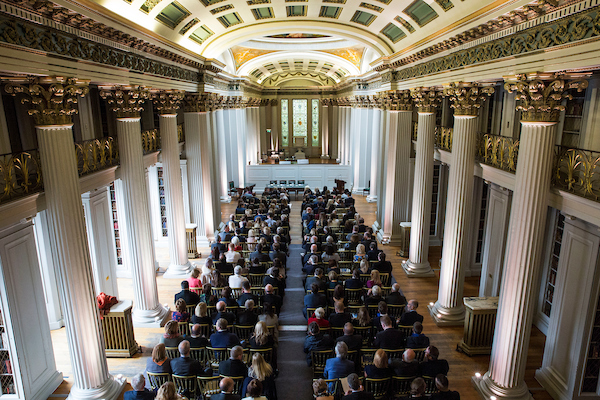 Ariel view of people seated in a grand room